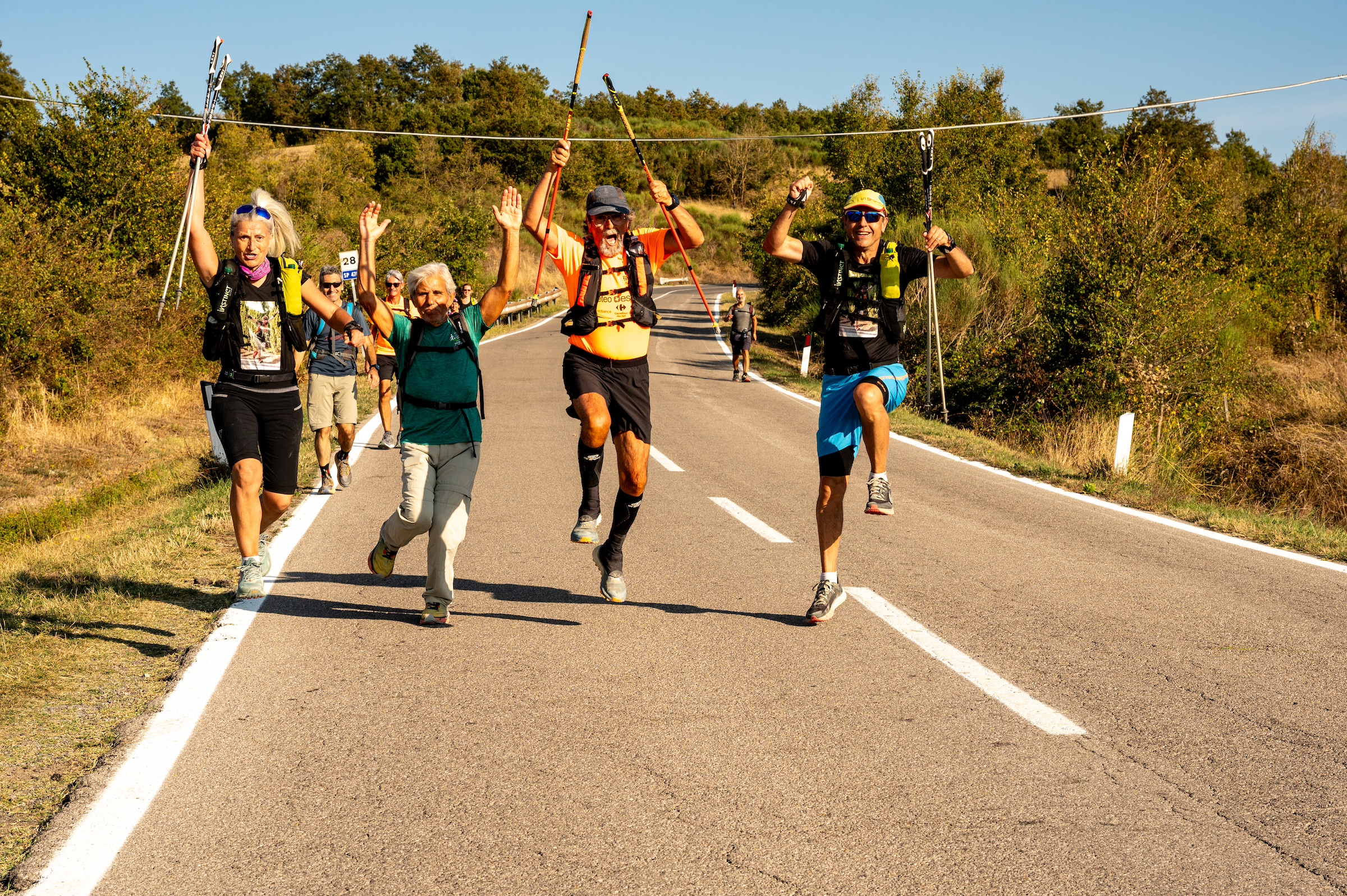 Atleti in corsa tra paesaggio collinare e strade toscane